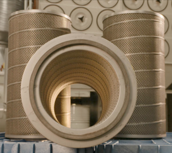 Replacement dust collector filters shown in front of an industrial dust collection system.