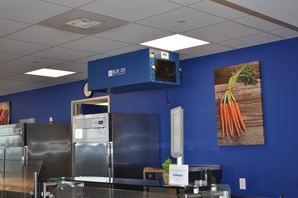 Blue Ox air cleaner shown installed in commercial kitchen to remove odors.
