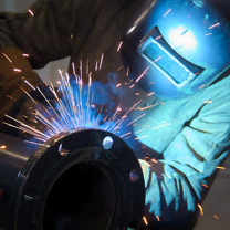 Worker welding on pipe
