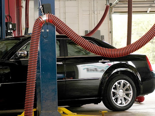 Car in a mechanic bay attached to a vehicle exhaust removal system