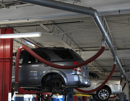 Image of a ducted vehicle exhaust extraction system connected to vehicles on a lift
