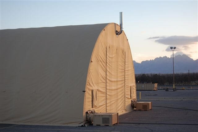 Military vehicle repair tent in the desert.