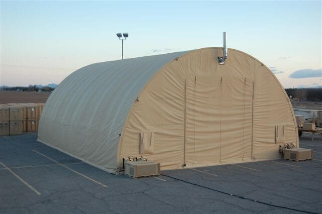 Military vehicle repair tent in the desert.