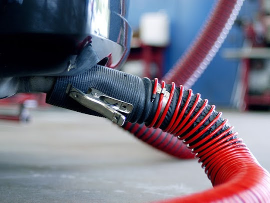 Fume-A-Vent vehicle exhaust removal system connected to the tailpipe of a passenger vehicle.