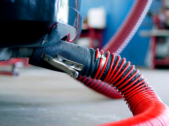 Fume-A-Vent vehicle exhaust removal system connected to the tailpipe of a passenger vehicle.