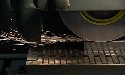 A grinder in operation and sparks generating from the work piece.