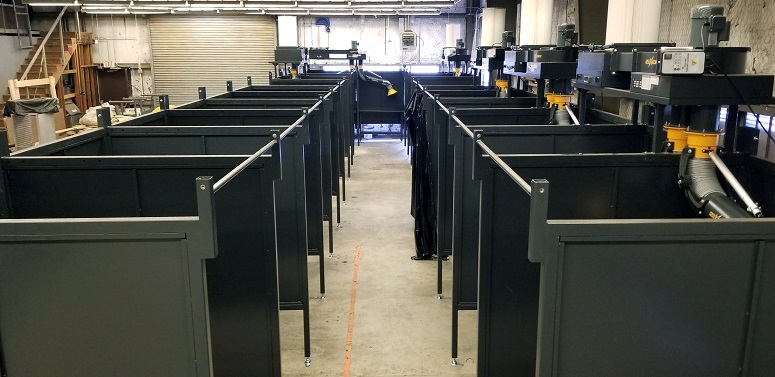 Overview of Fumextractors welding booths and fume extraction systems in a workshop.