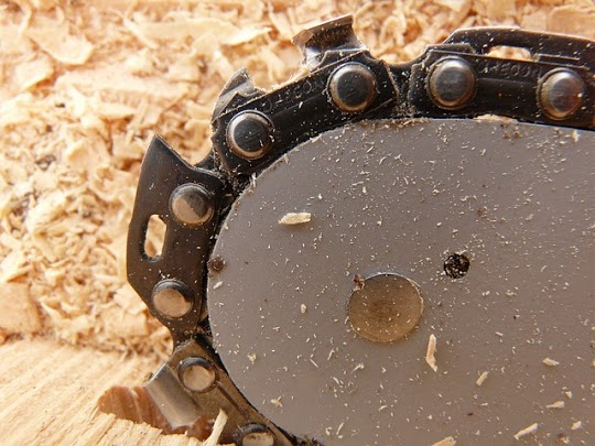 Image of chainsaw blade and wood dust